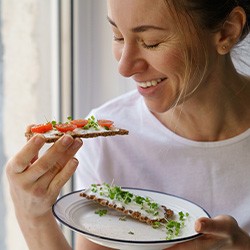 Woman smiling while eating snack at home