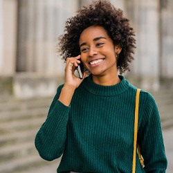 Woman smiling while talking on phone outside