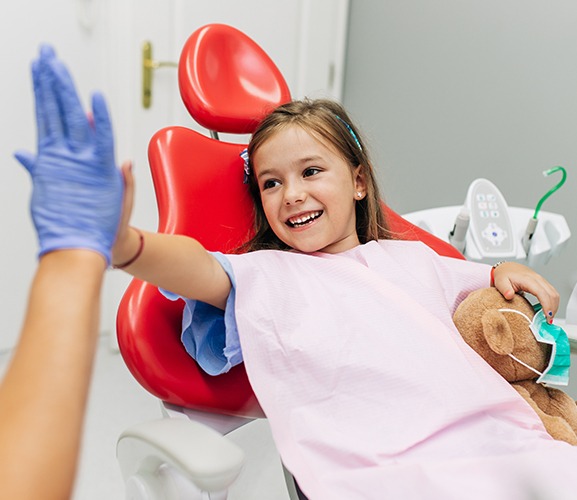 Little girl giving dentist a high five during her children's dentistry visit
