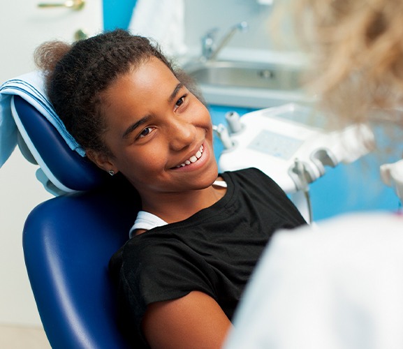 Patient smiling at dentist after pulp therapy