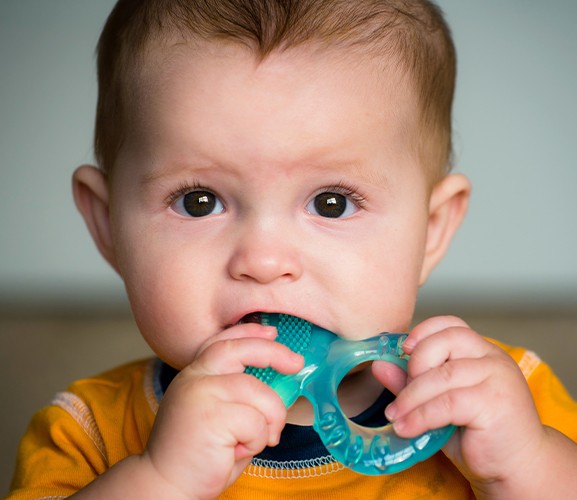 Toddler chewing on teething ring