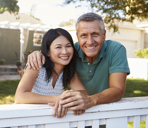 Man and woman sharing flawless smiles after metal free dental restorations