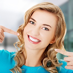 a dental patient pointing to her smile