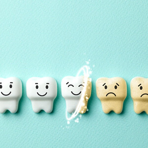 happy white toy teeth nexr to sad stained ones on a pale green background