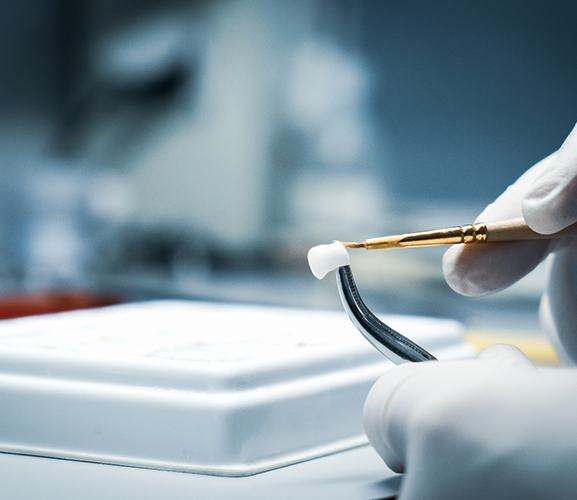 A lab worker processing dental crowns in Dallas