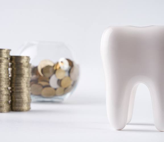 Coins next to a tooth