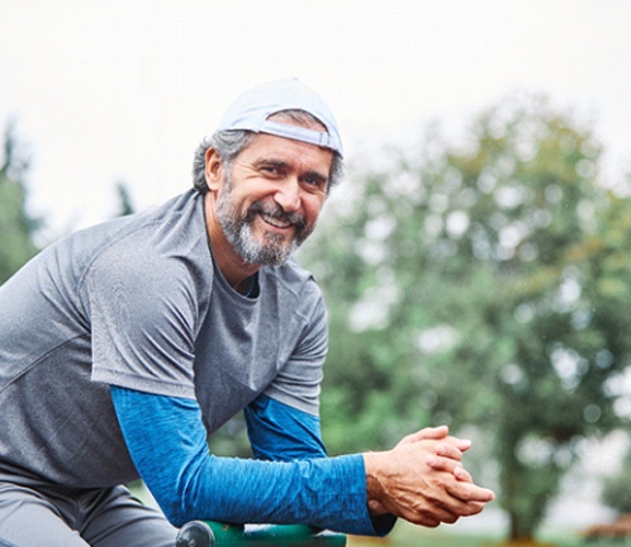 Man with a dental bridge in Dallas smiling on bicycle