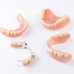 Four types of dentures arranged against neutral background