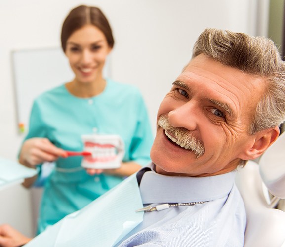 A man smiling while getting a denture