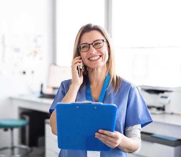 Dallas emergency dentist smiles while on the phone with a patient