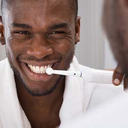 Man saves money on emergency dental care in Dallas by brushing his teeth