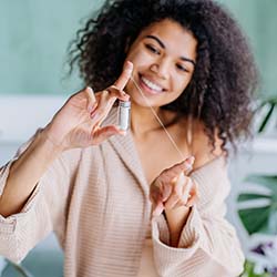 Woman using floss to prevent dental emergencies in Dallas