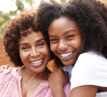 Smiling mother and daughter hugging