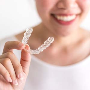 person holding an Invisalign aligner
