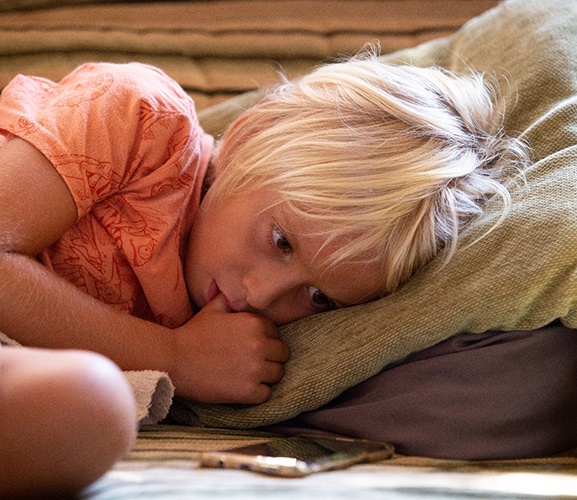 Young child sucking their thumb while lying down
