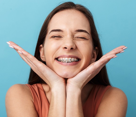 Smiling patient with traditional braces orthodontics