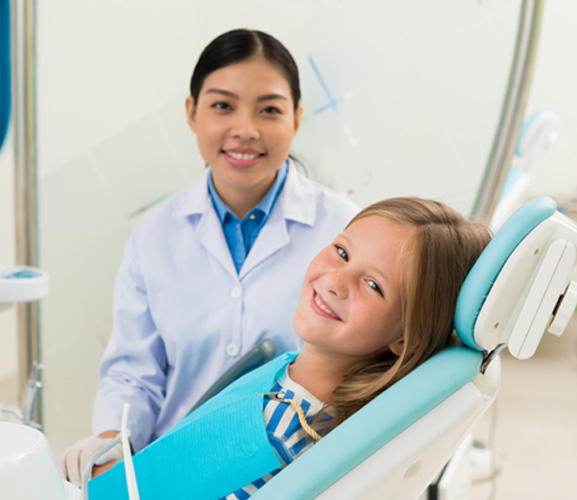 Young dental patient posing with her dentist