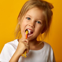 young girl brushing her teeth 