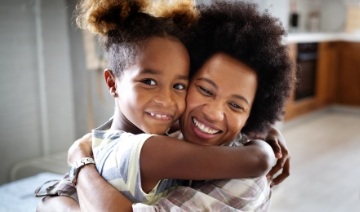 Mother hugging daughter after children's dentistry treatment