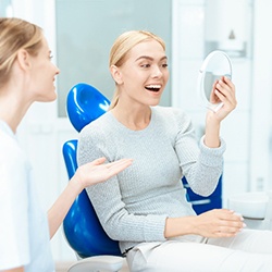 A woman enjoying her nice smile in a hand mirror