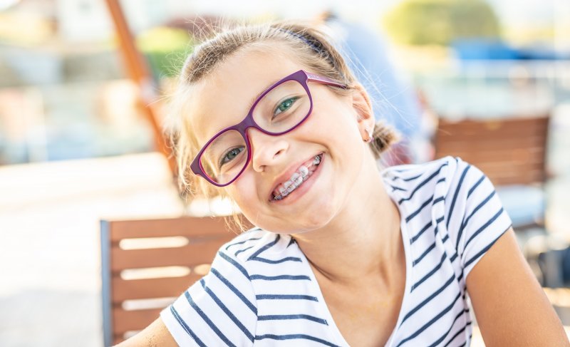 Young girl smiling after learning fun facts about braces