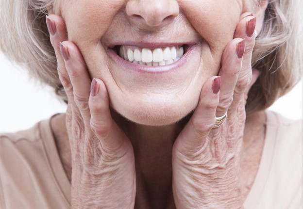 patient smiling after having ill-fitting dentures fixed