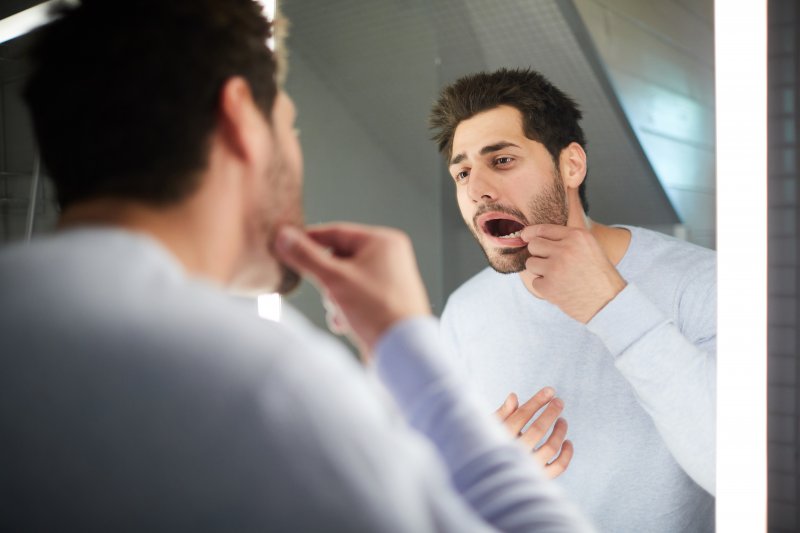 Man looking at his loose dental crown