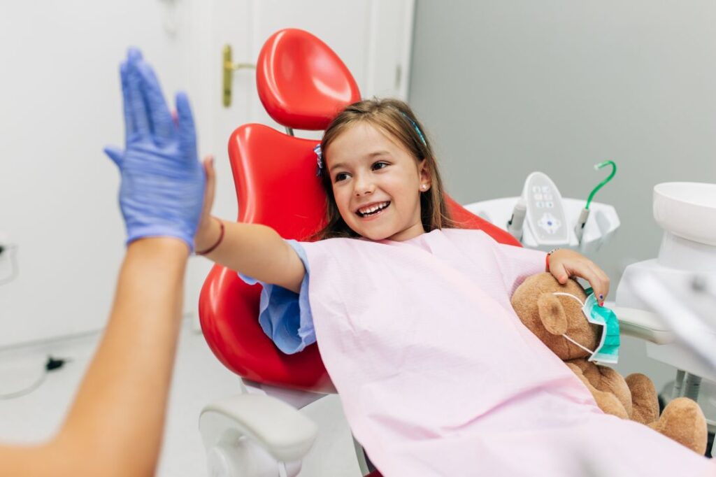 A little girl high-fiving a dentist