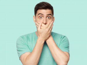 Man covering mouth after dental crown fell out